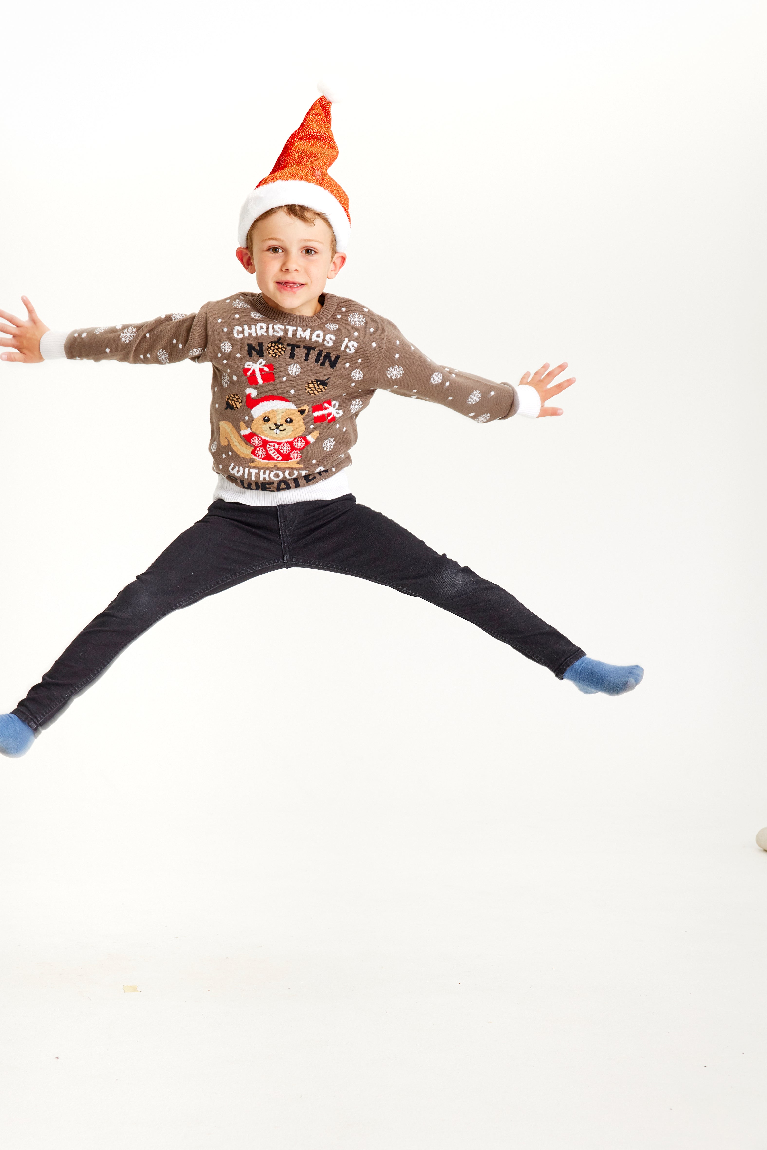 Et hoppende barn i brun julegenser med ekorn.